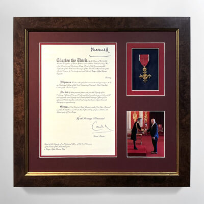 A MBE, photo and letter, double mounted onto to red mountboards in a smooth wooden frame with a gold trim