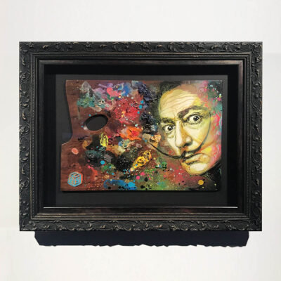 A Salvador Dali portrait on an art pallet in an ornate grey frame