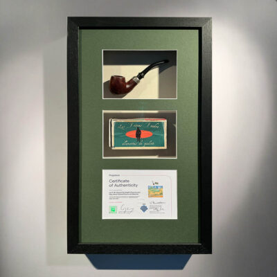 Two Doctor Who props in green mountboard in a smooth black wooden frame